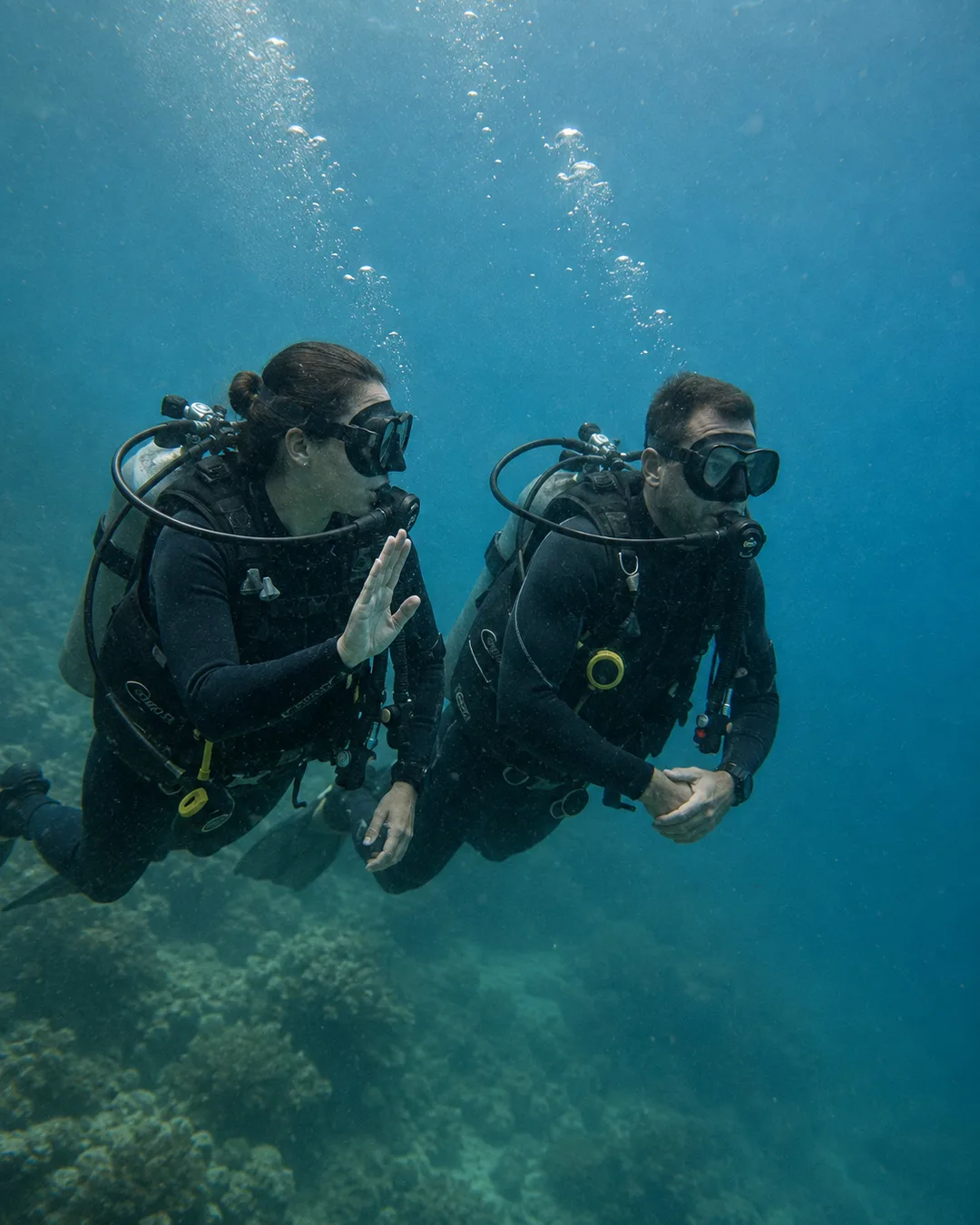 Two divers maintaining awareness of each other underwater